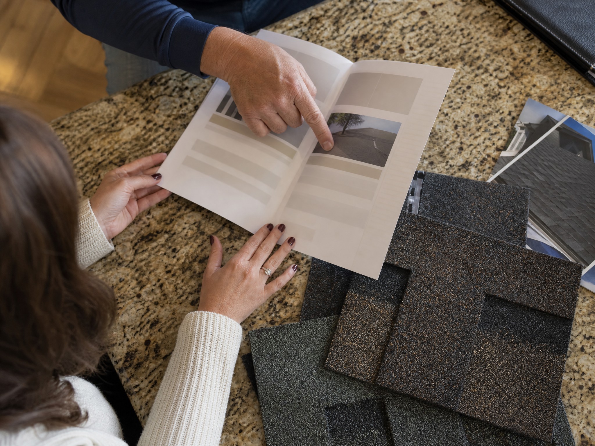 Homeowner reviewing a roof warranty document at a kitchen table